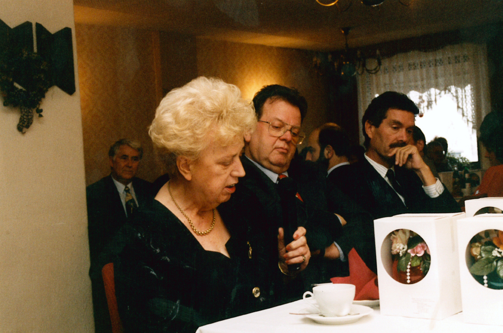 Mit Firmenerbin Barbara Fischer (1926 –2005) und Mark Seidscheck, Hauptgeschäftsführer des Bundesfachverbandes der Arzneimittel-Hersteller (BAH) während des 90-jährigem Firmenjubiläum im Jahr 1996. (eine Frau und 2 Männer sitzen an einem Tisch)  